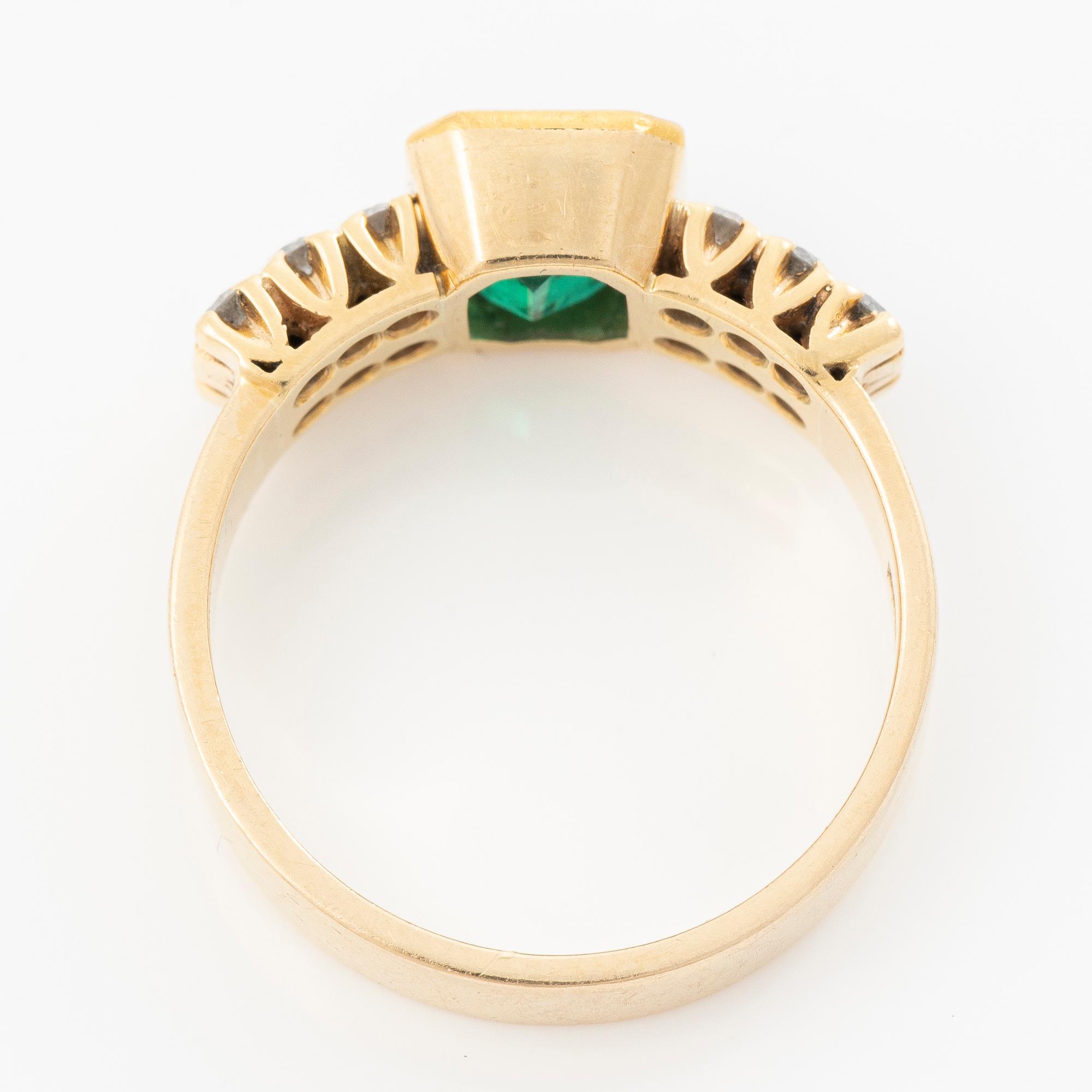 Ring 18k guld med en fasettslipad smaragd och runda briljantslipade diamanter.