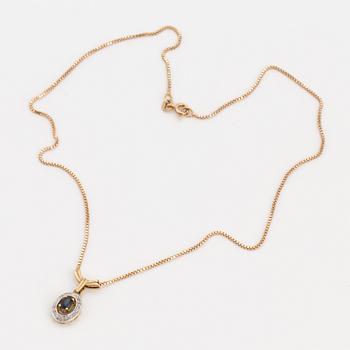 An 18K gold chain and pendant set with an oval, mixed-cut, synthetic sapphire surrounded by eight-cut diamonds.