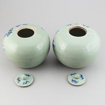A pair of Chinese celadon glazed and blue and white jars with covers, 20th century.