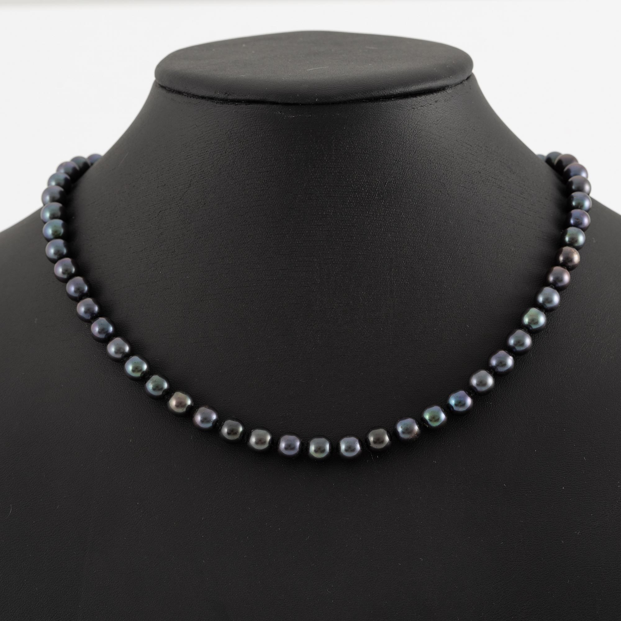 Necklace of cultured freshwater pearls, clasped with 14K white gold and round brilliant-cut diamonds.