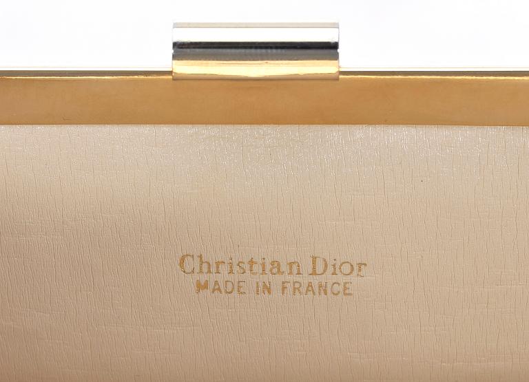 A white monogram canvas clutch by Christian Dior.