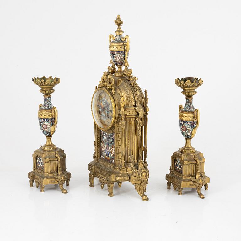 A set of two Louis XVI-style candle sticks and a mantle clock, late 19th century.