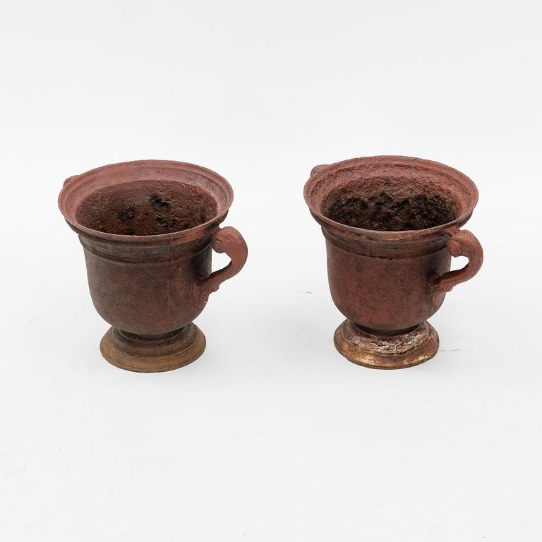 A pair of cast iron garden urns, 20th Century.