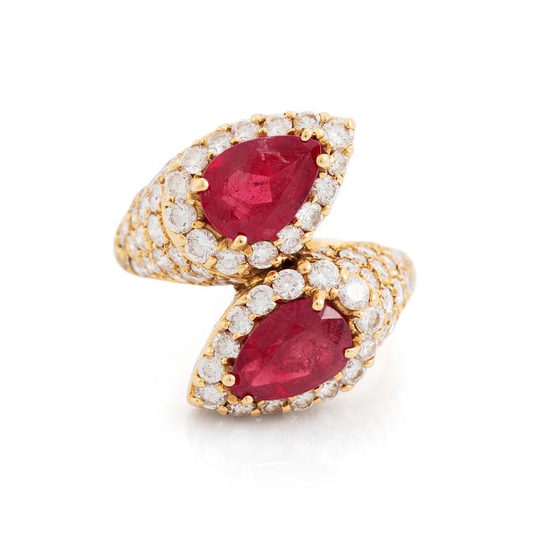 An 18K gold ring set with two facted rubies and round brilliant-cut diamonds.