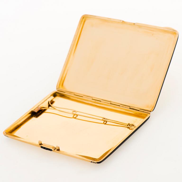 A Cartier Art Deco cigarette case in 18K gold with black enamel and set with sapphires.