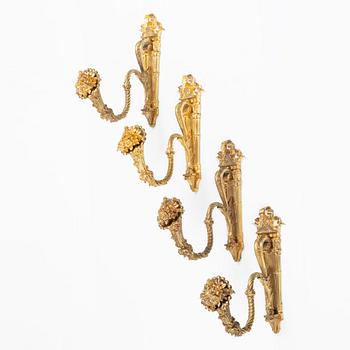 A set of four gilt bronze Louis XVI-style curtain holders, late 19th century.
