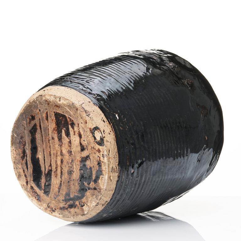 A large black glazed jar, presumably late Ming dynasty.