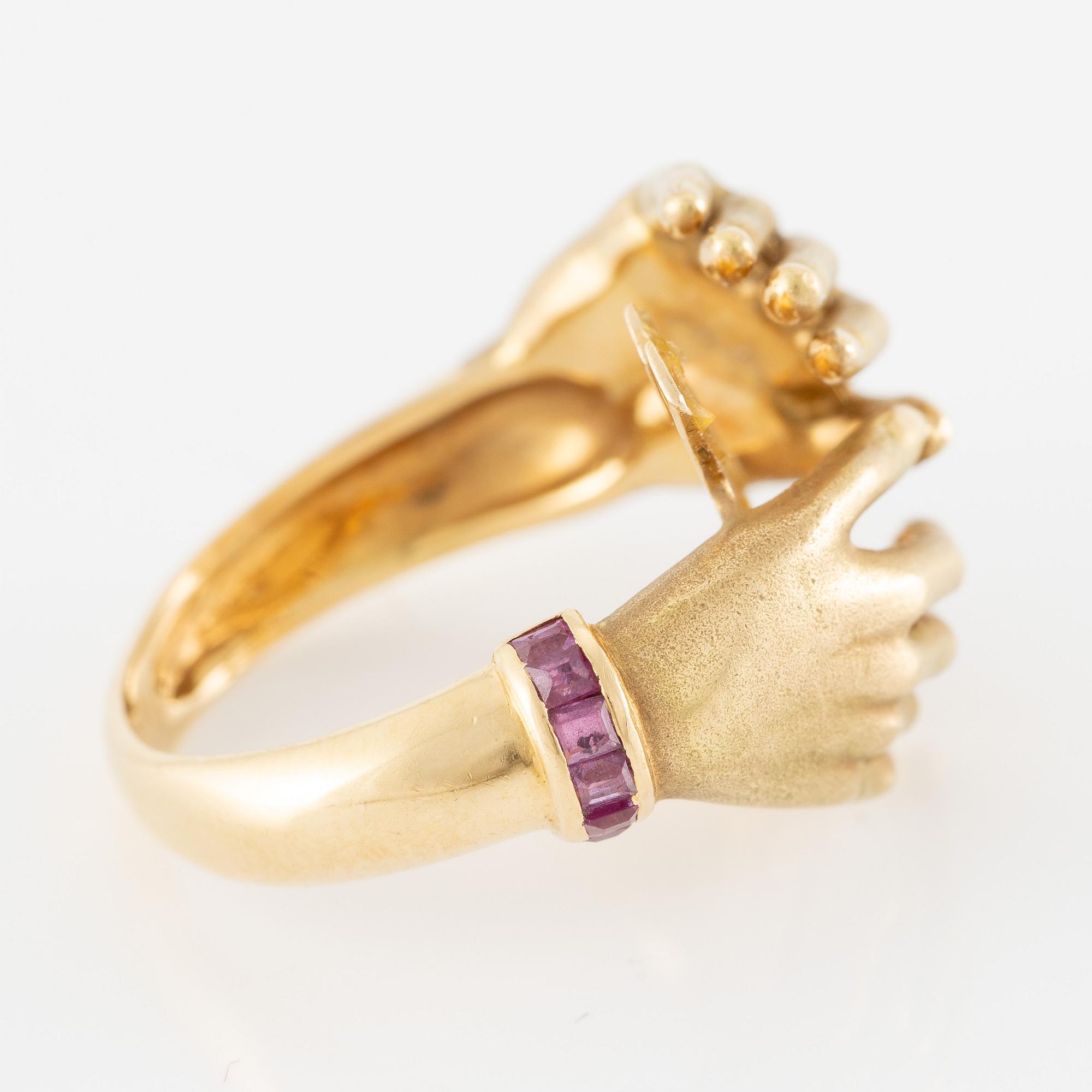 Ring, 18K gold in the form of hands, set with carré-cut rubies.