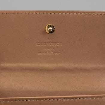 A beige monogram vernis wallet by Louis Vuitton.