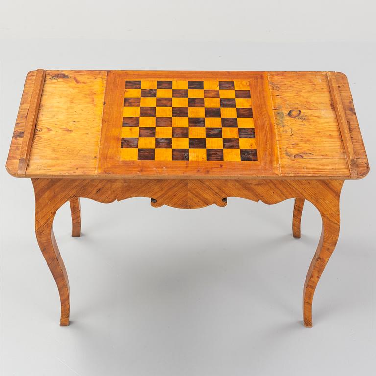 An elm veneered Rococo games table, 18th Century.