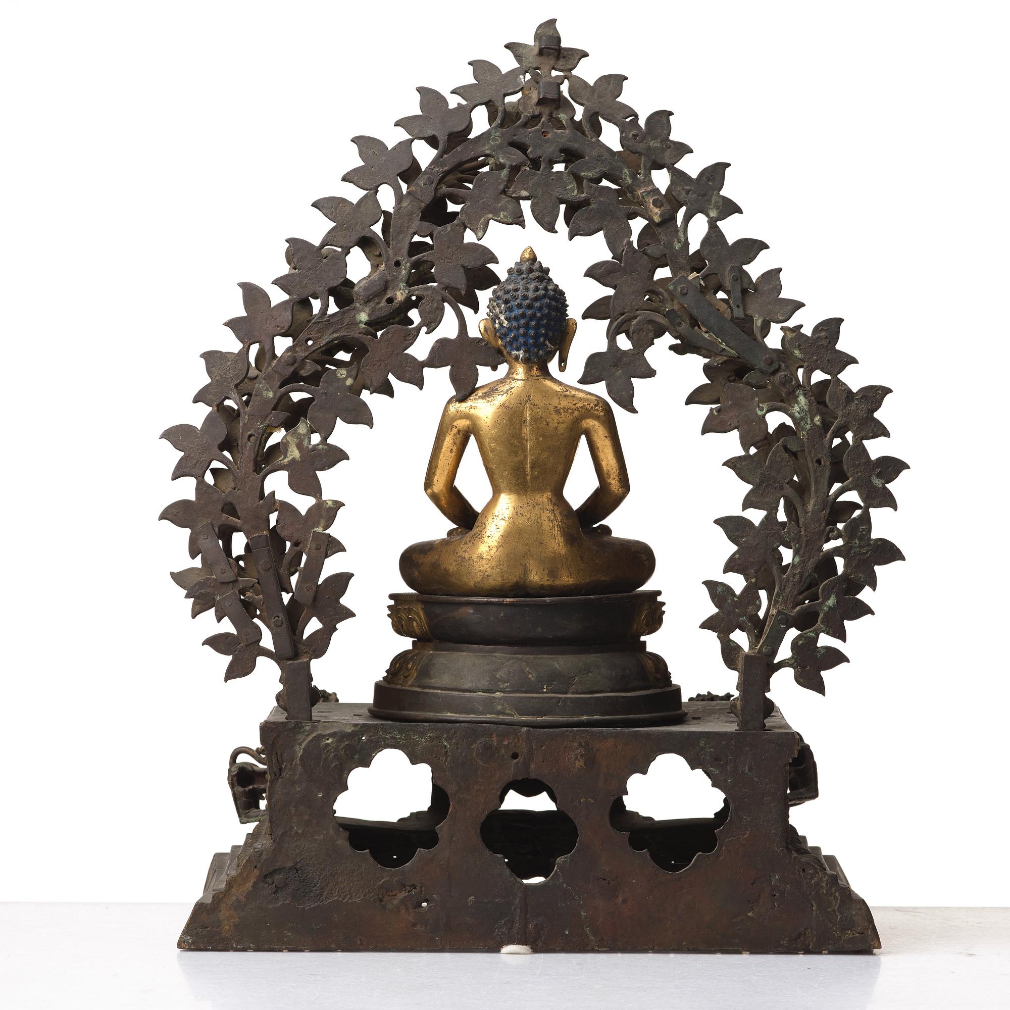 A large Nepalese gilt bronze buddha on a throne with mandorla, 18/19th Century.