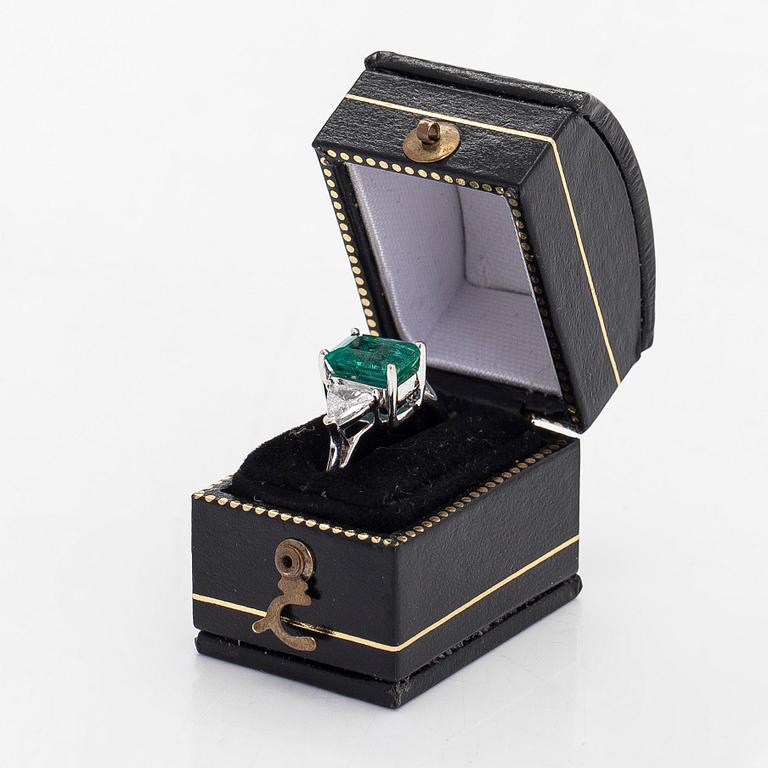 An 18K white gold ring, set with a Zambian emerald and trillion-cut diamonds.