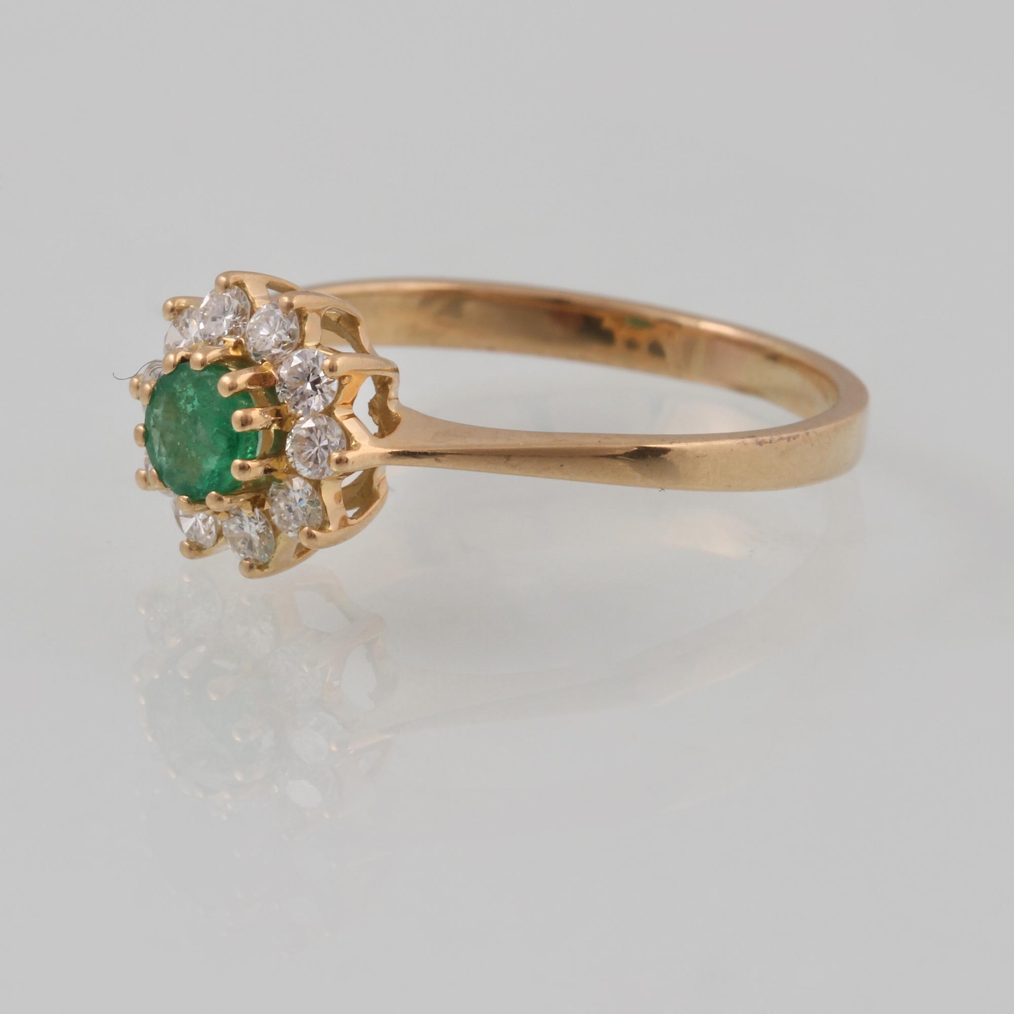 RING, 18K guld med fasettslipad smaragd samt 10 briljantslipade diamanter ca 0.10 ct,  importstämplad. Vikt 2,4 gram.