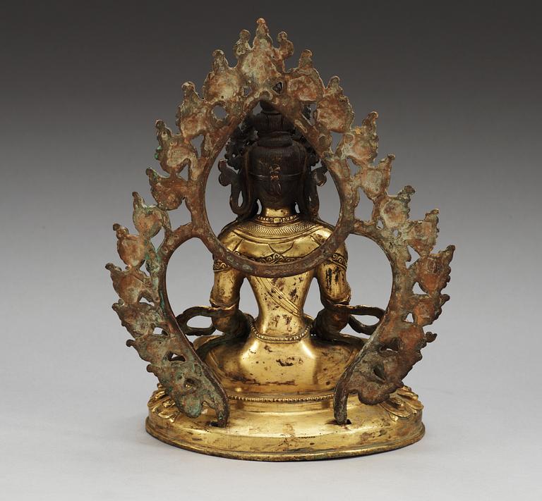 A gilt bronze seated figure of Amitayus, with separately cast nimbus, Qing dynasty (1644-1911).