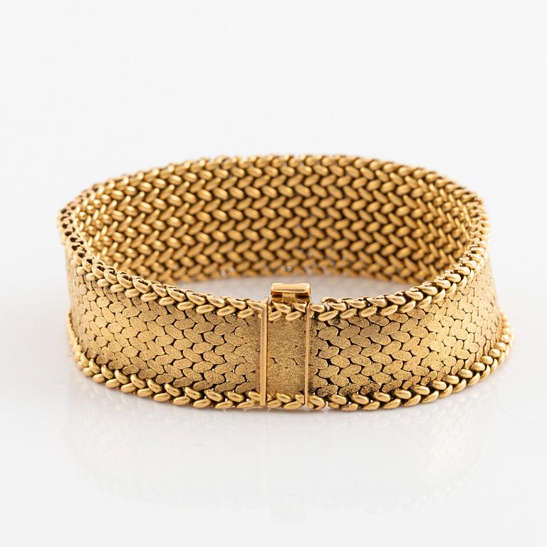 An 18K gold bracelet set with round brilliant-cut diamonds and rubies.