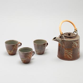 A tea pot and three tea cups in saltglazed stoneware by Christer Sjöblom, signed tea pot.