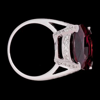RING, oval faceted spessartite garnet, 18.90 cts, and brilliant cut diamonds, tot. 0.77 cts.