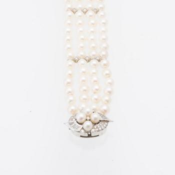 Bracelet 4-row with cultured pearls, round brilliant-cut and baguette-cut diamonds, and clasp in 14K white gold.