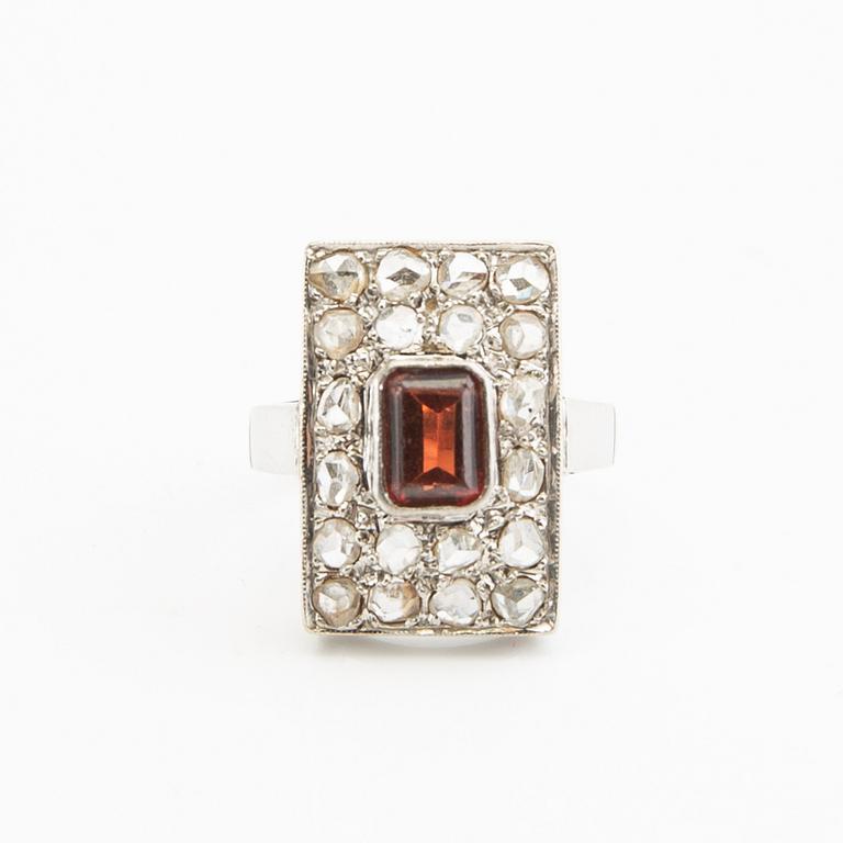 Ring, 18K white gold with a red stone (possibly garnet) and diamonds.