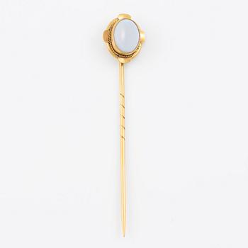 Brooch pin of low-grade gold with a white-blue stone.