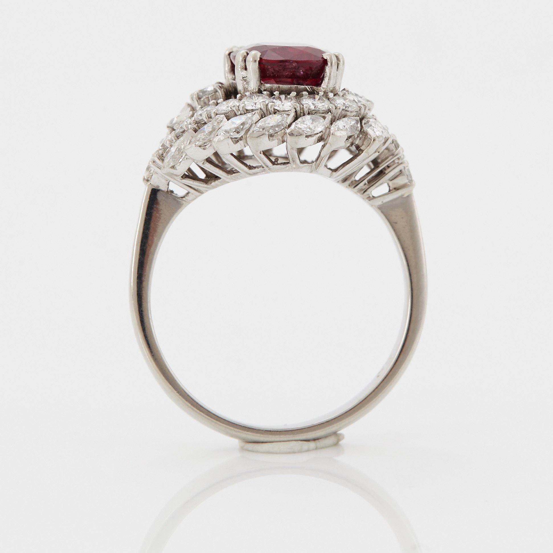 Ring platina med en fasettslipad rubin och runda briljant- och navettslipade diamanter.