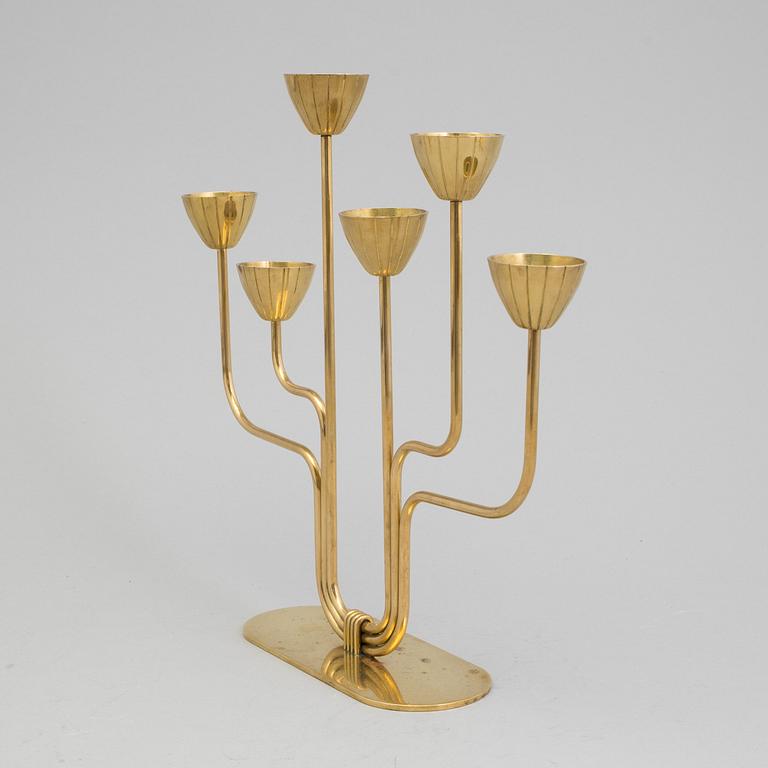 A brass candelabrum and two candlesticks by Ystad Metall, Gunnar Ander.