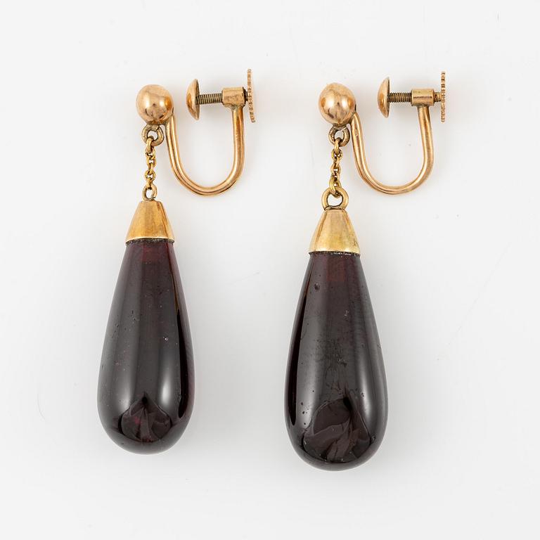A pair of 14K gold earrings with garnet drops.