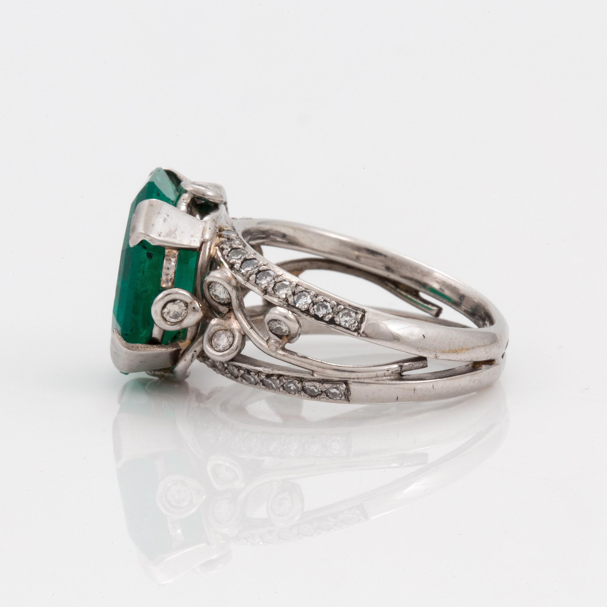 An octagonal cut 6.50 ct emerald and brilliant cut diamond ring. Mandelstam 'Ice Age'.