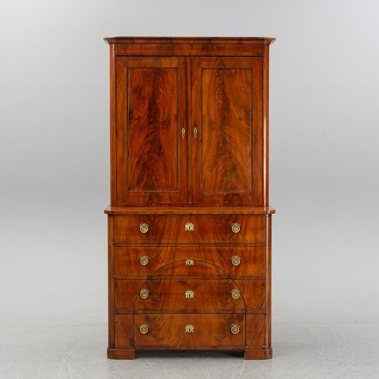 A mahogany veneered Empire cupboard, first half of the 19th century.