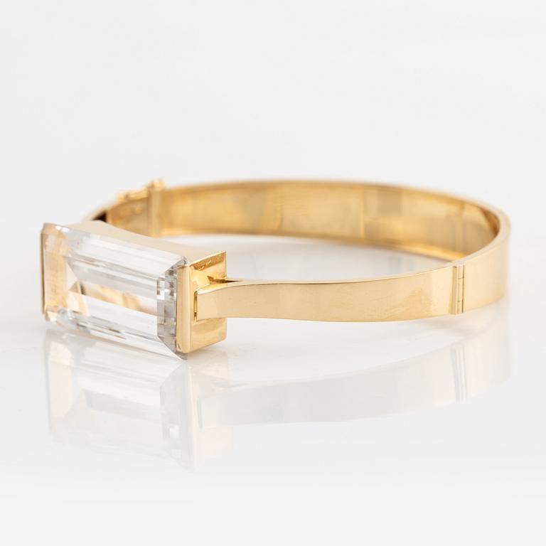 An 18K gold bangle set with synthetic spinel.