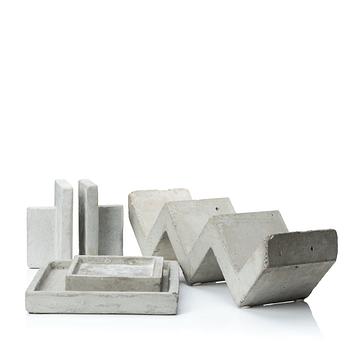 A mixed lot comprising a pair of limestone bookends, a bookshelf and two plates in concrete.