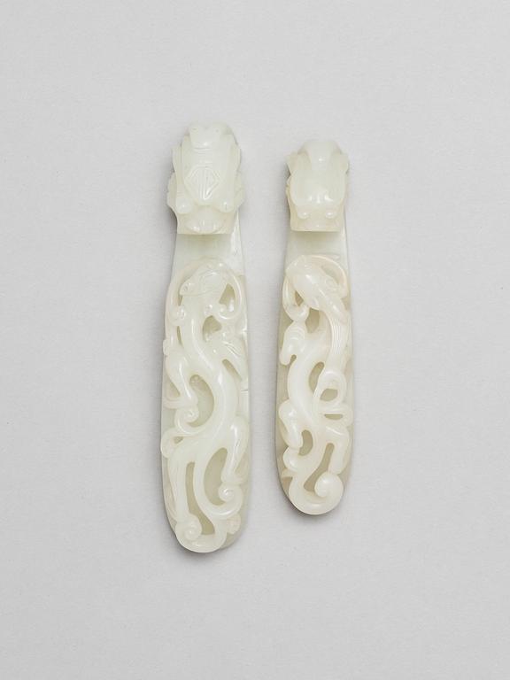 Two pale green nephrite garment hooks, Qing dynasty.