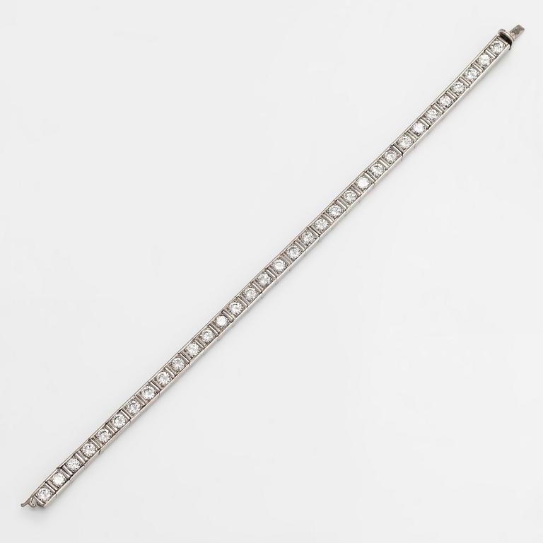 A platinum tennis bracelet with brilliant cut diamonds totalling approx. 5.61 ct. With certificate.