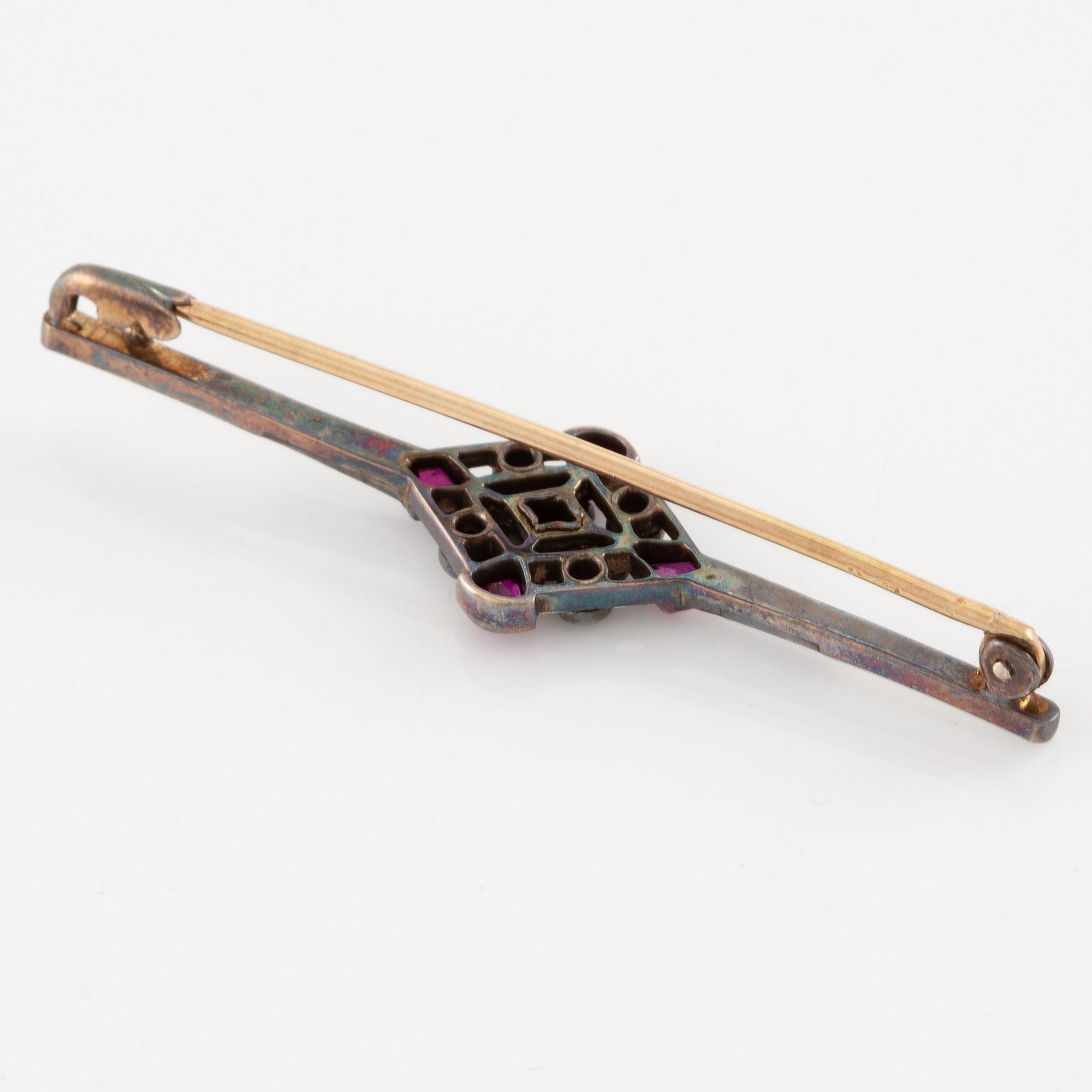 Brooch platinum and 14K gold set with old- and rose-cut diamonds and red stones.