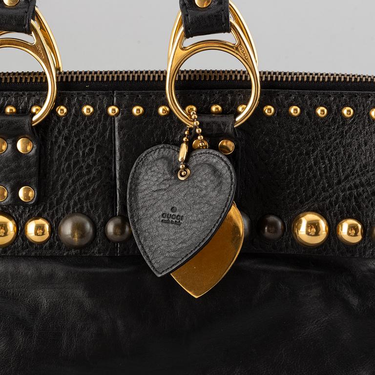 Gucci, a black leather handbag.