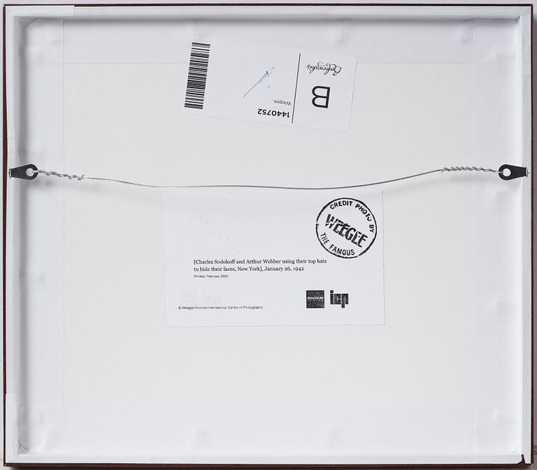 Weegee, "Charles Sodokoff and Arthur Webber using their top hats to hider their faces, New York, January 26 1942".