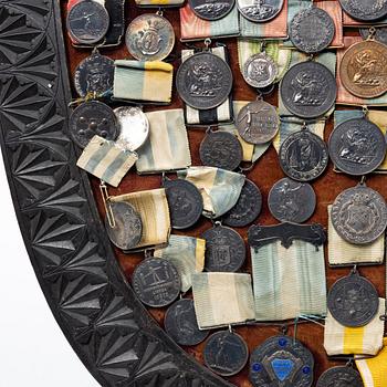 Idrottsmedaljer på märkessköld. Delvis silver. Sverige 1900-talets första hälft.