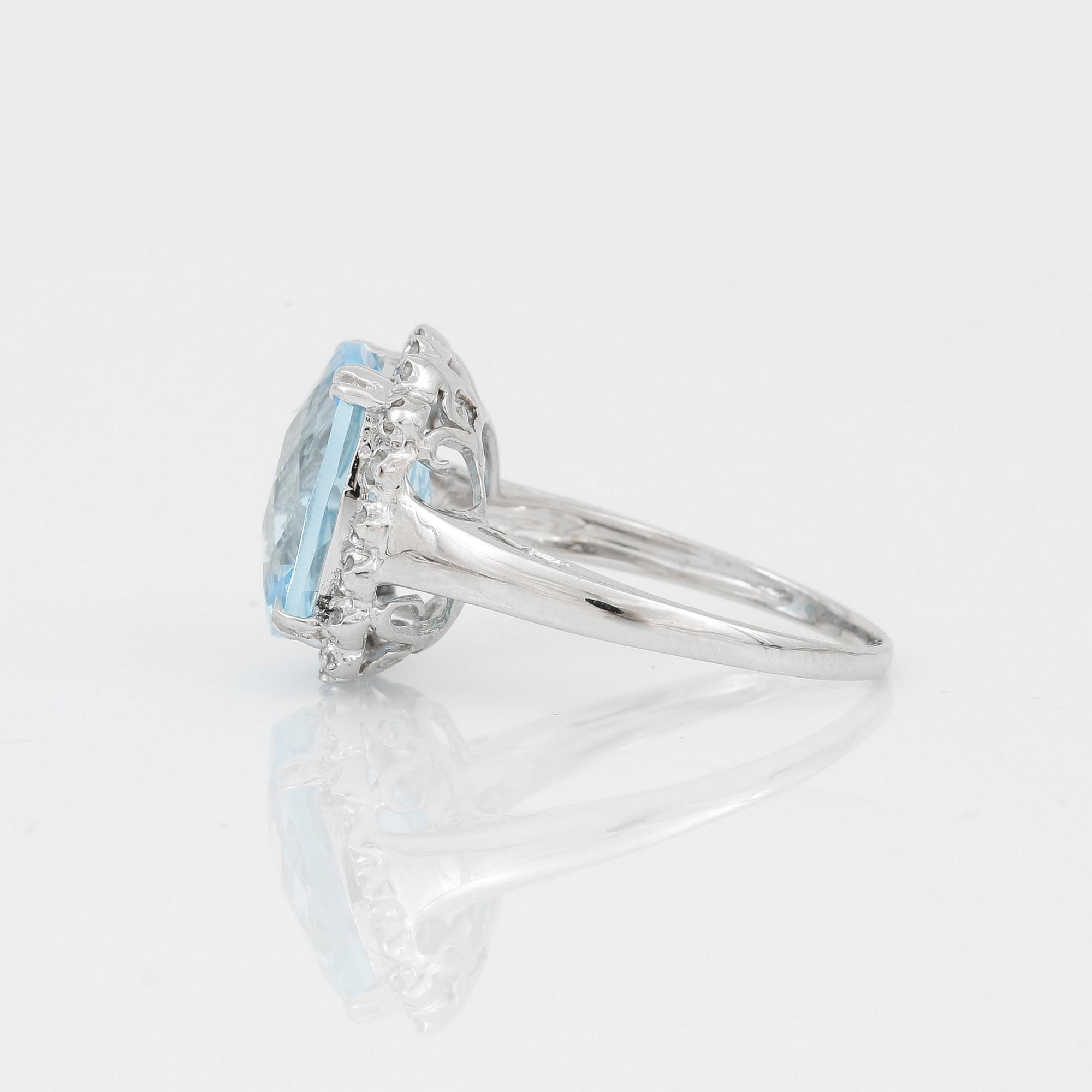 RING, 18K vitguld med chequerslipad blå topas, ca 5,23 ct, diamanter tot ca 0,20 ct. Vikt ca 4,17 g.