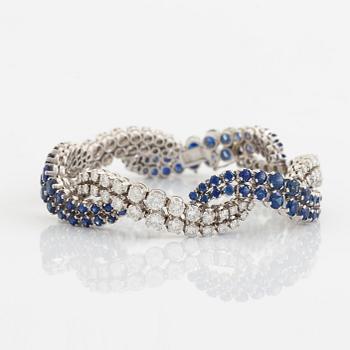 An 18K white gold bracelet set with round brilliant-cut diamonds and sapphires.