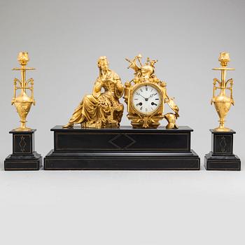 A late 19th century table clock and a pair of candlesticks.