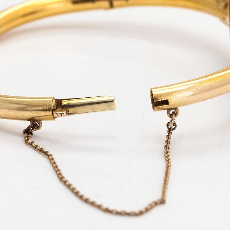 An 18K gold bangle, with rubies, cultured pearls and rose-cut diamonds.
