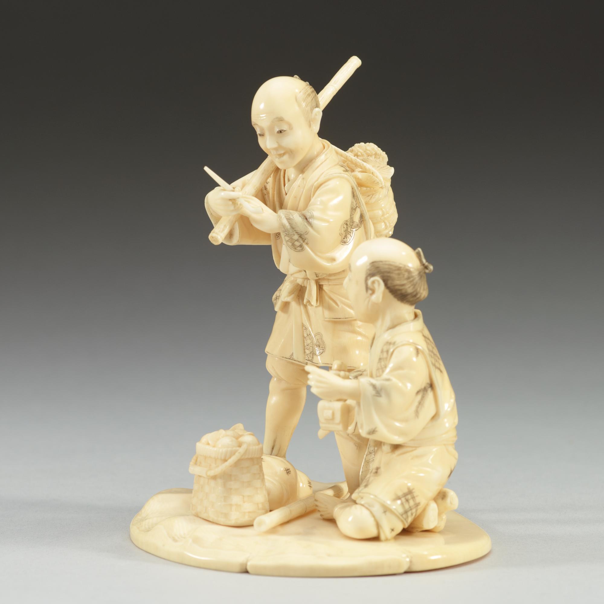 A Japanese ivory sculpture of two men, period of Meiji (1868-1912). Signed.