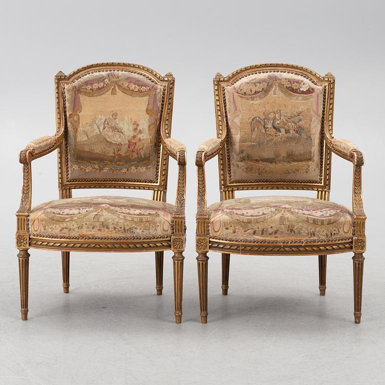 A pair of Louis XVI-style armchairs, late 19th century with 18th century fabric.