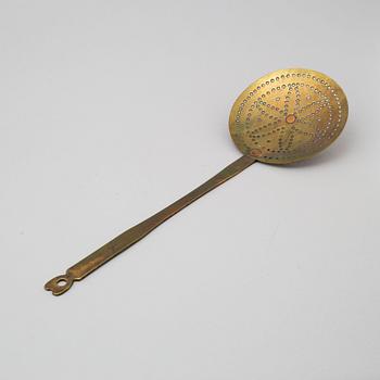 An 18th century brass strainer.