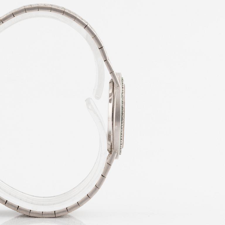 A Piaget 18K white gold wrist watch set with round brilliant-cut diamonds and step-cut emeralds.
