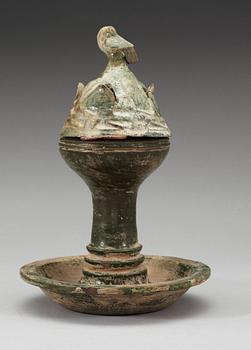 A green glazed pottery Hill Jar, cover with bird shaped finial, Han dynasty (206 BC-AD 220).