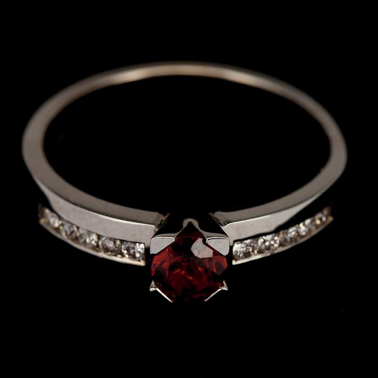 RING, vitguld 14K med granat 0,40 ct. och 10 st briljantslipade diamanter tot. 0,16 ct. Vikt 5 g.