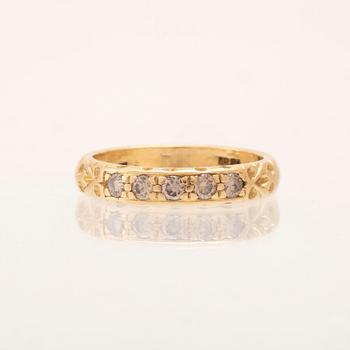 An 18K gold half-eternity ring set with round brilliant-cut diamonds.