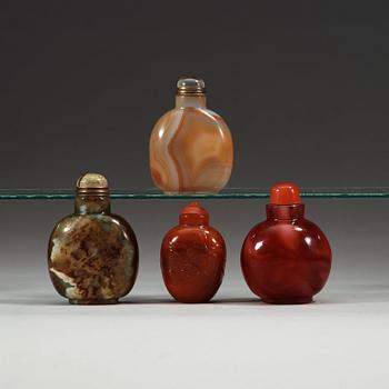 A set of four glass and stone snuff bottles with stoppers.