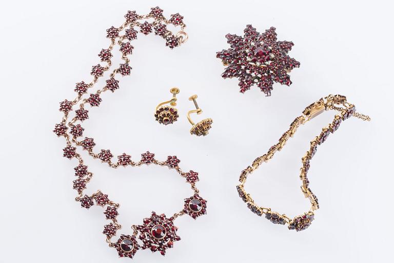 HALSBAND, BROSCH, ARMBAND samt ÖRHÄNGEN, ett par, med fasetterade granater, troligen omkring sekelskiftet 1900.